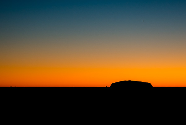 Uluru in silhouette at sunrise. 