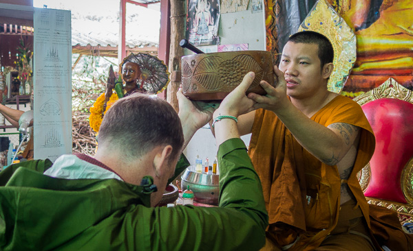 Receiving a blessing and making an offering to the Ajarn.