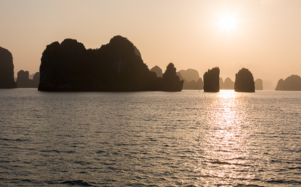 Sunset in Halong Bay, with the limestone karsts in the foreground. 